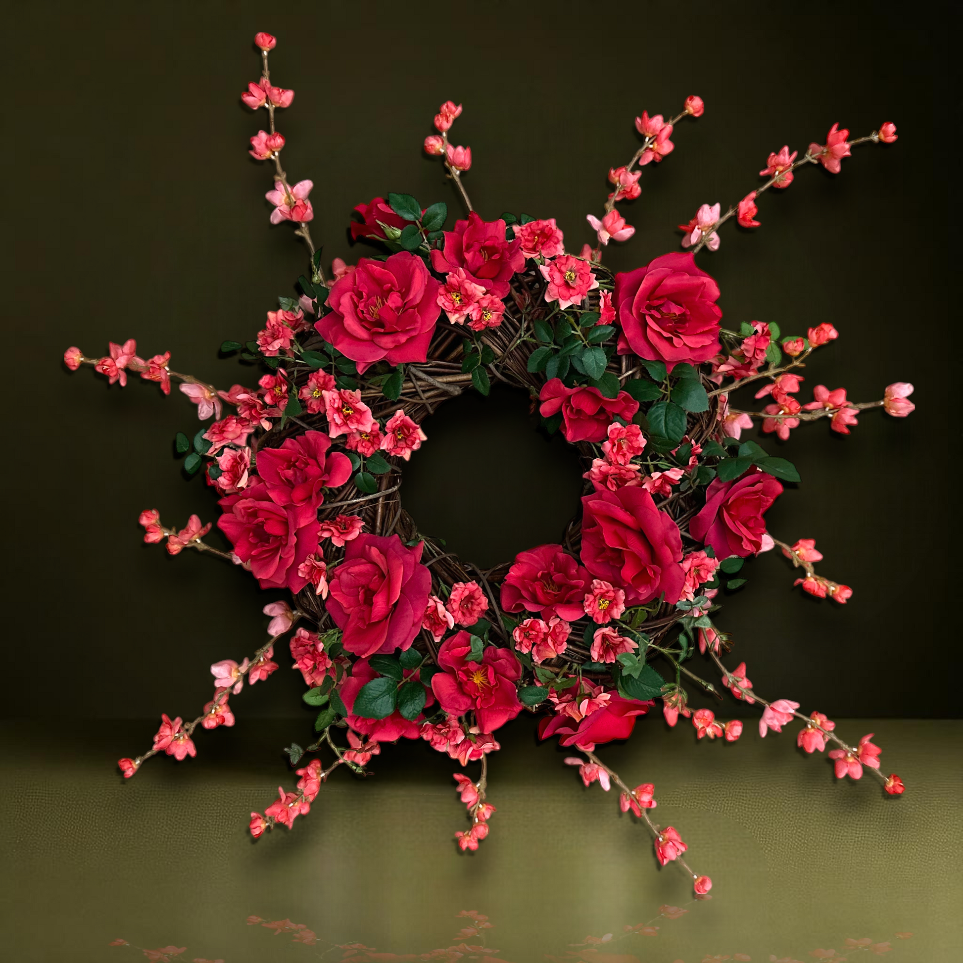 Handgemaakte luxe deurkrans met felle rode en fuchsia kunstrozen, delicate kersenbloesems en levendig groen blad, speels en asymmetrisch gerangschikt op een natuurlijke basis van takken. Deze expressieve bloemenkrans van Jardin Enchanté straalt passie, romantiek en mediterrane flair uit. Perfect als opvallende kunstbloemenkrans voor de voordeur, muurdecoratie of feestelijke gelegenheden. Ideaal voor wie een elegante, luxe seizoensdecoratie zoekt die direct een statement maakt.