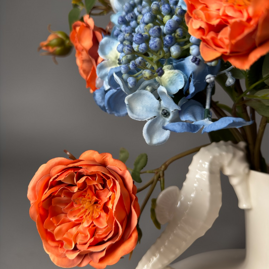 Burnt Apricot & Blue Mini Boeket met hoogwaardige zijden oranje tuinrozen en blauwe hortensia’s gestyled in een witte keramische vaas voor stijlvolle woondecoratie