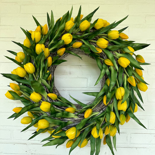 Handgemaakte luxe deurkrans met heldere gele kunsttulpen, kunstig gerangschikt op een natuurlijke, gevlochten takkenbasis. Deze opvallende tulpenkrans van Jardin Enchanté brengt direct zonneschijn en een warme, vrolijke uitstraling naar uw voordeur of interieur. Perfect als seizoensdecoratie voor de lente en zomer, en ideaal voor wie op zoek is naar een unieke luxe kunstbloemenkrans of stijlvolle deurdecoratie. Deze exclusieve krans combineert elegantie en levendige kleuren om een uitnodigende en verfijnde 