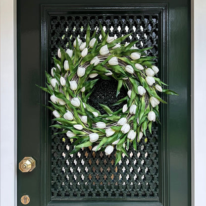Handgemaakte luxe deurkrans met elegante witte kunsttulpen, zorgvuldig gerangschikt op een natuurlijke gevlochten basis van takken, perfect voor een stijlvolle voordeurdecoratie of als muurdecoratie binnenshuis. Deze exclusieve tulpenkrans van Jardin Enchanté straalt tijdloze verfijning en een romantische, frisse uitstraling uit. Ideaal voor wie op zoek is naar een bijzondere seizoensdecoratie, lente- of zomerkrans, of luxe kunstbloemen krans voor een warm en uitnodigend huis.