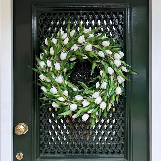 Handgemaakte luxe deurkrans met elegante witte kunsttulpen, zorgvuldig gerangschikt op een natuurlijke gevlochten basis van takken, perfect voor een stijlvolle voordeurdecoratie of als muurdecoratie binnenshuis. Deze exclusieve tulpenkrans van Jardin Enchanté straalt tijdloze verfijning en een romantische, frisse uitstraling uit. Ideaal voor wie op zoek is naar een bijzondere seizoensdecoratie, lente- of zomerkrans, of luxe kunstbloemen krans voor een warm en uitnodigend huis.