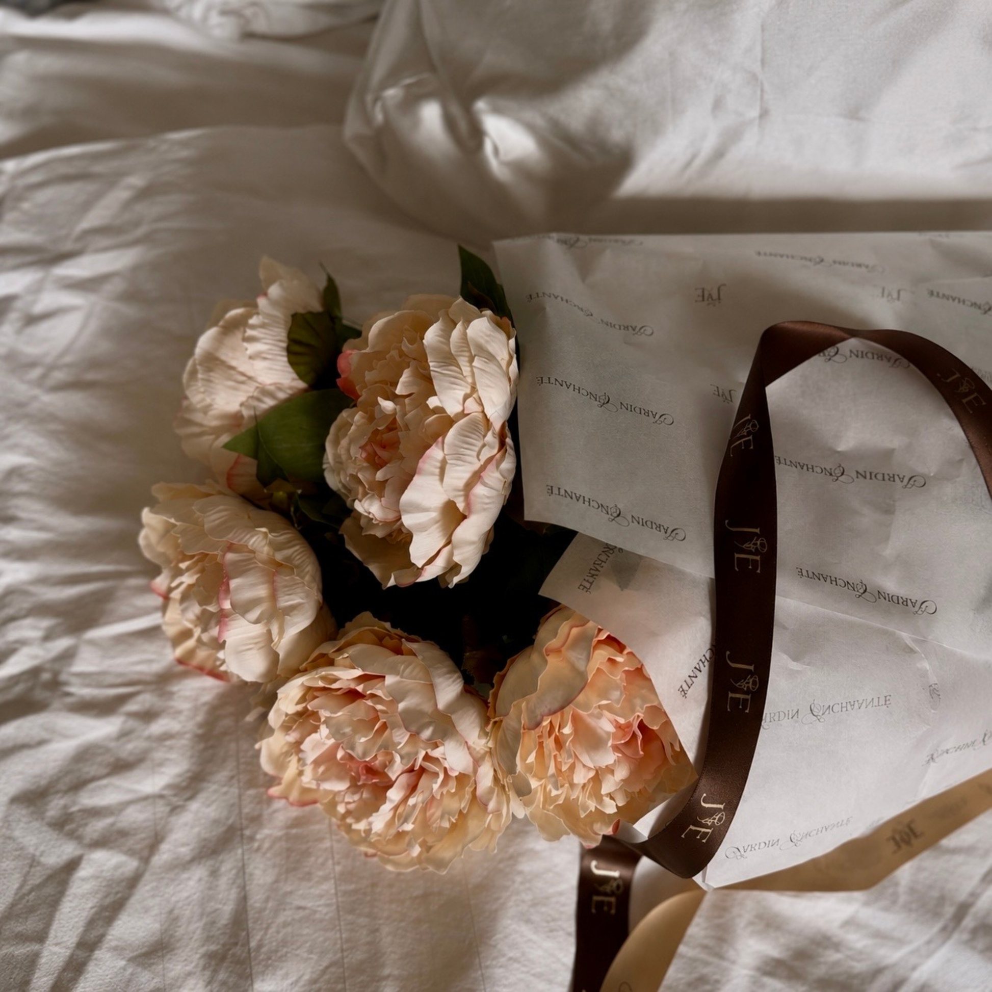 Realistic artificial peach peony flower stem for elegant home decor and floral styling in branded gift tissue paper and silk ribbon