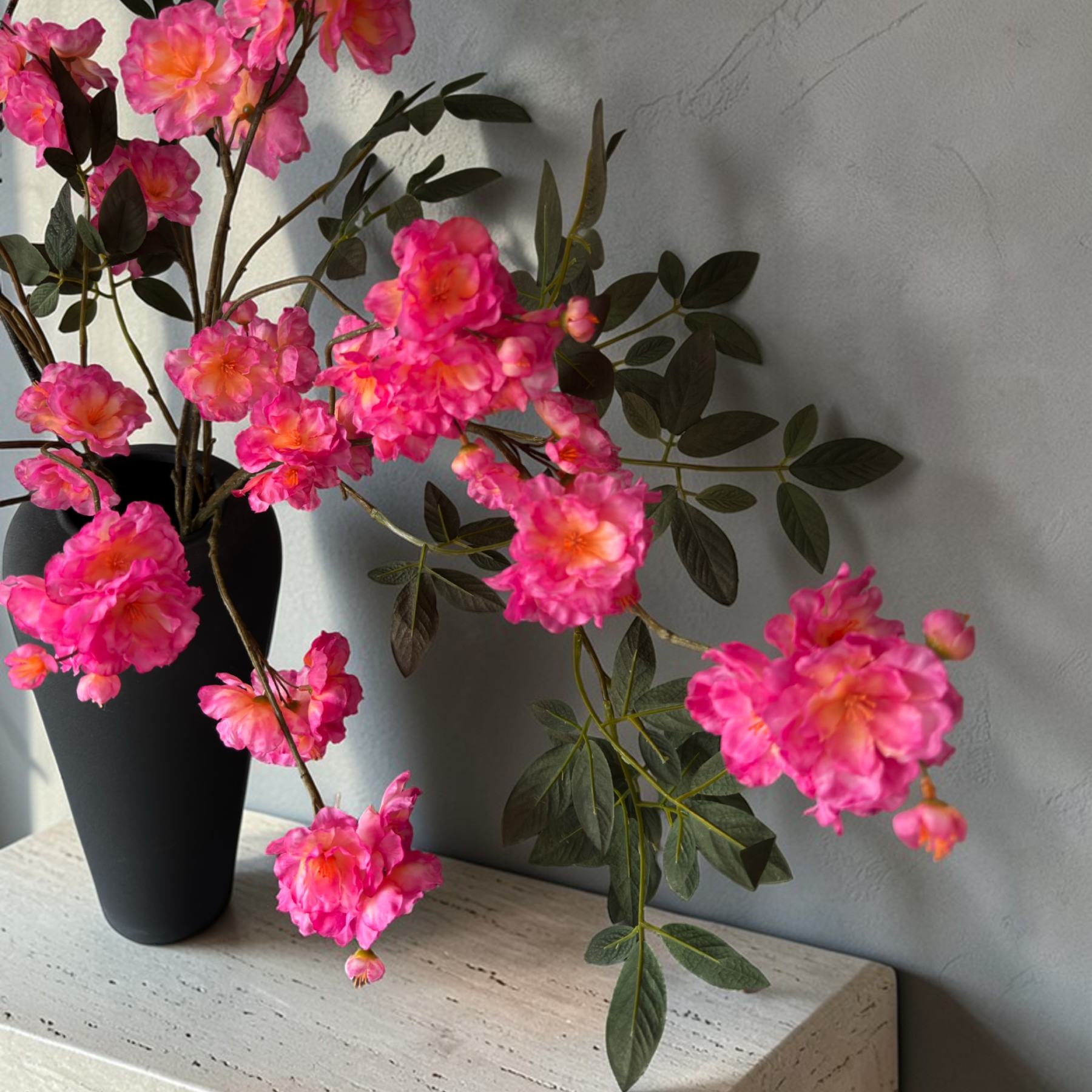 Wild Blossom Bouquet with high-quality silk pink blossoms and natural branches arranged in a tall black vase for elegant home decor and interior styling.