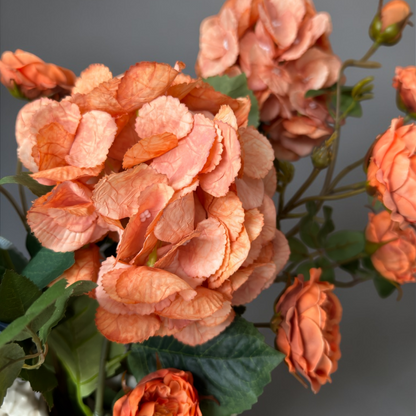 Burnt Apricot & Blue Mini Bouquet with high-quality silk orange garden roses and blue hydrangeas styled in a white ceramic vase for elegant home decor