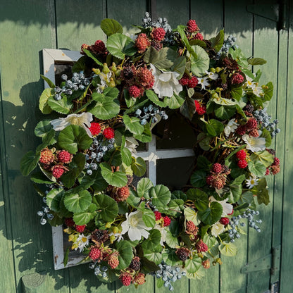 Handgemaakte luxe deurkrans met kunstzwarte bessen, frambozen, blauwe bessen, witte bloemen en rijk groen blad, kunstig gerangschikt op een natuurlijke, gevlochten takkenbasis. Deze betoverende boskrans van Jardin Enchanté brengt een elegante, wilde en sprookjesachtige uitstraling aan je voordeur of interieur. Perfect als seizoensdecoratie voor zomer en herfst, en ideaal voor liefhebbers van luxe kunstbloemenkransen en exclusieve deurdecoraties. Deze natuur geïnspireerde krans creëert een warme, poëtische s