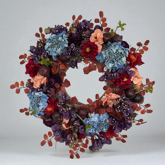 Handmade autumn wreath with deep burgundy peonies, blue hydrangeas, peach blossoms, and red zinnias, accented with rustic apples and fall foliage. This seasonal door wreath combines rich jewel tones and natural textures, creating an elegant fall decoration for entryways and interiors.