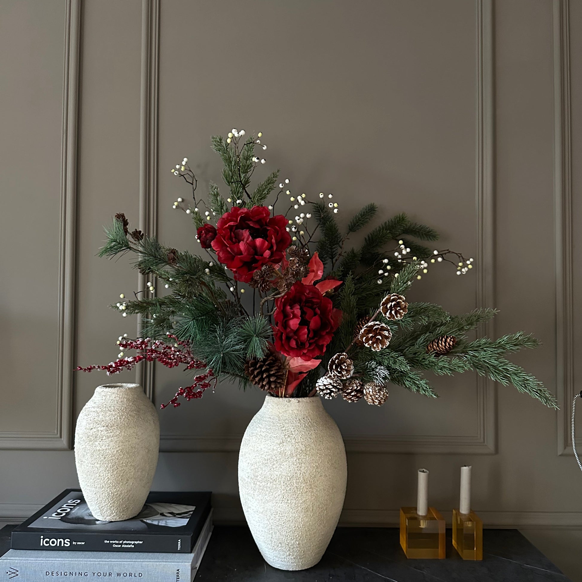 Luxe winterboeket met rode pioenrozen, dennentakken en dennenappels, handgemaakt door Jardin Enchanté. Elegant kunstbloemen boeket voor kerst en winterdecoratie, met natuurlijke uitstraling en warme seizoenskleuren. Perfect voor stijlvolle interieurdecoratie of als feestelijk cadeau.