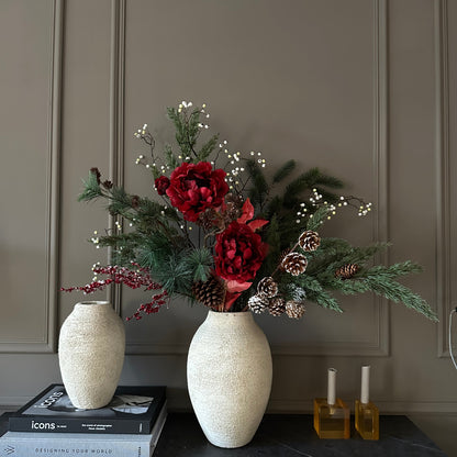 Luxe winterboeket met rode pioenrozen, dennentakken en dennenappels, handgemaakt door Jardin Enchanté. Elegant kunstbloemen boeket voor kerst en winterdecoratie, met natuurlijke uitstraling en warme seizoenskleuren. Perfect voor stijlvolle interieurdecoratie of als feestelijk cadeau.