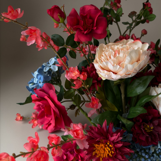 Coral Garden Boeket met hoogwaardige zijden bloemen in koraal, rood, blush en blauwe tinten gestyled in een witte keramische vaas voor stijlvolle woondecoratie