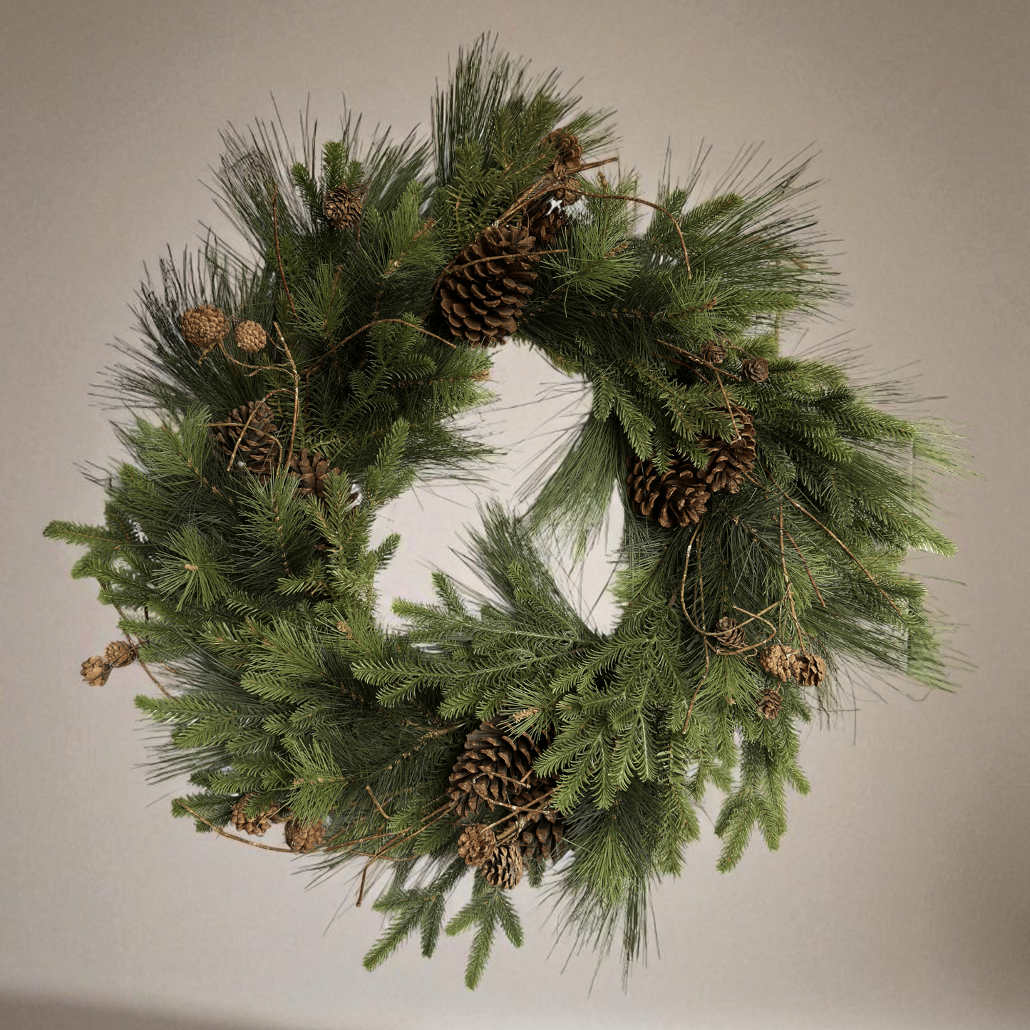 Luxe kunstkerstkrans met dennenappels en groen, stijlvol opgehangen aan een moderne voordeur — perfecte duurzame kerstdecoratie voor buiten.