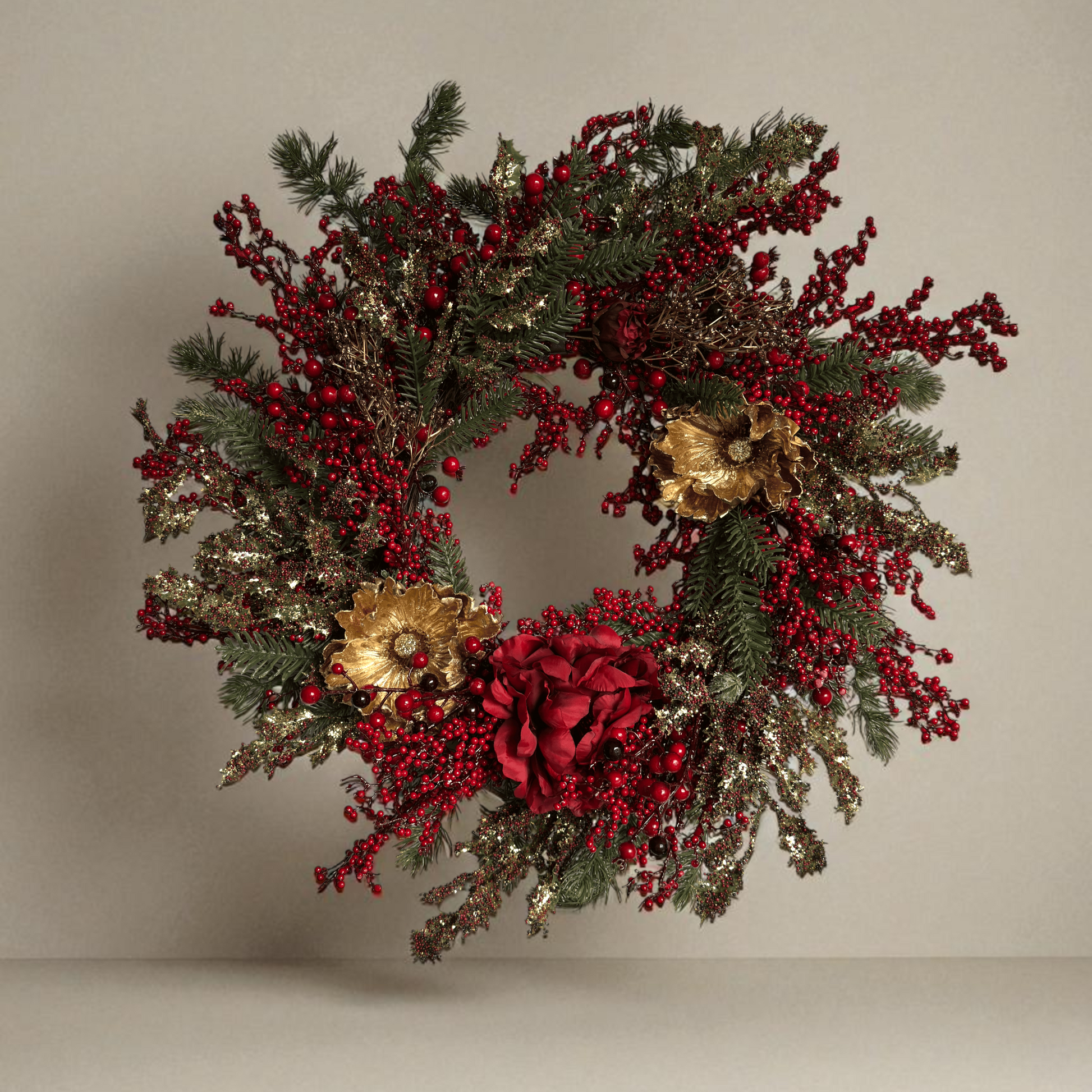 Luxe kunstkerstkrans met rode bessen, gouden bloemen en dennetakken, opgehangen aan een moderne grijze voordeur – stijlvolle kerstdecoratie met feestelijke uitstraling.