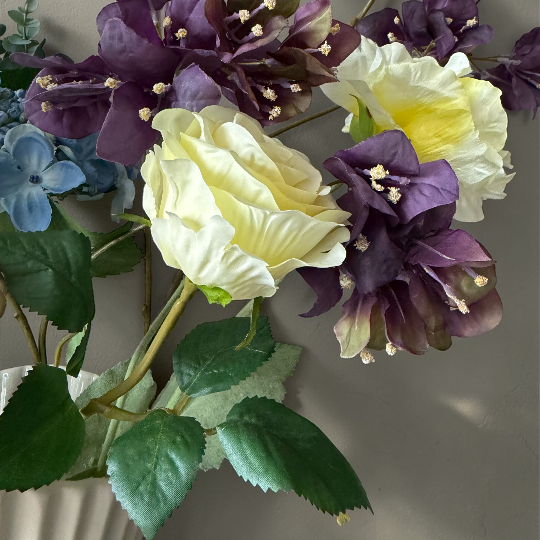 Luxury silk flower bouquet in plum, yellow and blue tones with blossom branches and hydrangea styled in a white vase for timeless home decor.