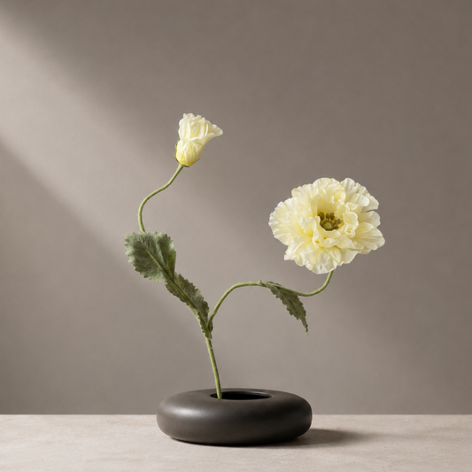 Premium artificial yellow papaver flower stem styled in a sculptural black vase against a warm neutral background