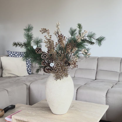 Luxe winterboeket Whispering Pines van Jardin Enchanté – handgemaakt kunstboeket met dennetakken, gouden accenten, dennenappels en champagnekleurig blad. Perfect als stijlvolle kerstdecoratie, tafeldecoratie of winterse woonaccessoire. Hoogwaardige zijden bloemen en kunstgroen zorgen voor een natuurlijke uitstraling die jarenlang mooi blijft.