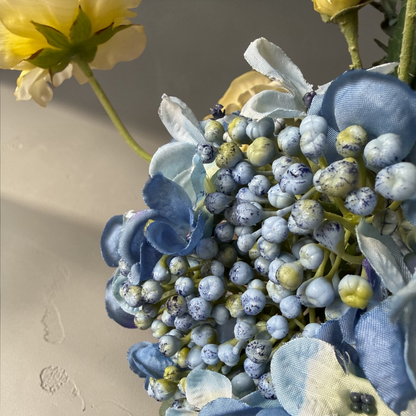 Plum Garden Boeket met hoogwaardige zijden bloemen in diepe pruim, zacht geel en blauwe tinten gestyled in een witte vaas voor stijlvolle woondecoratie en interieur styling.