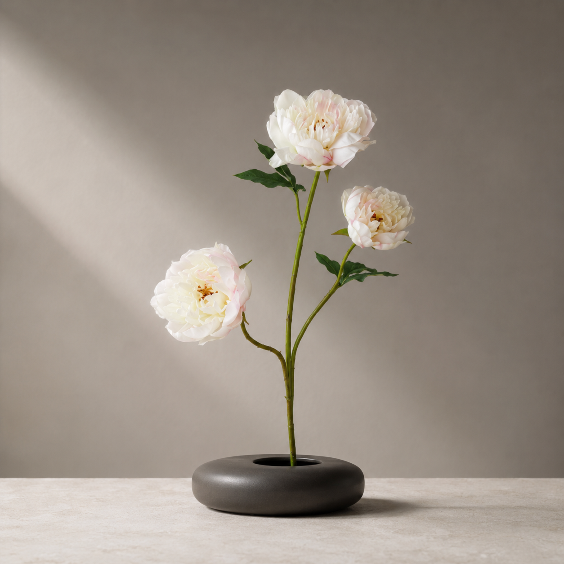 Real touch cream pink peony stem with lifelike petals styled in a sculptural black vase