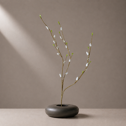 Real touch grey pussy willow stem styled in a sculptural black vase against a neutral background
