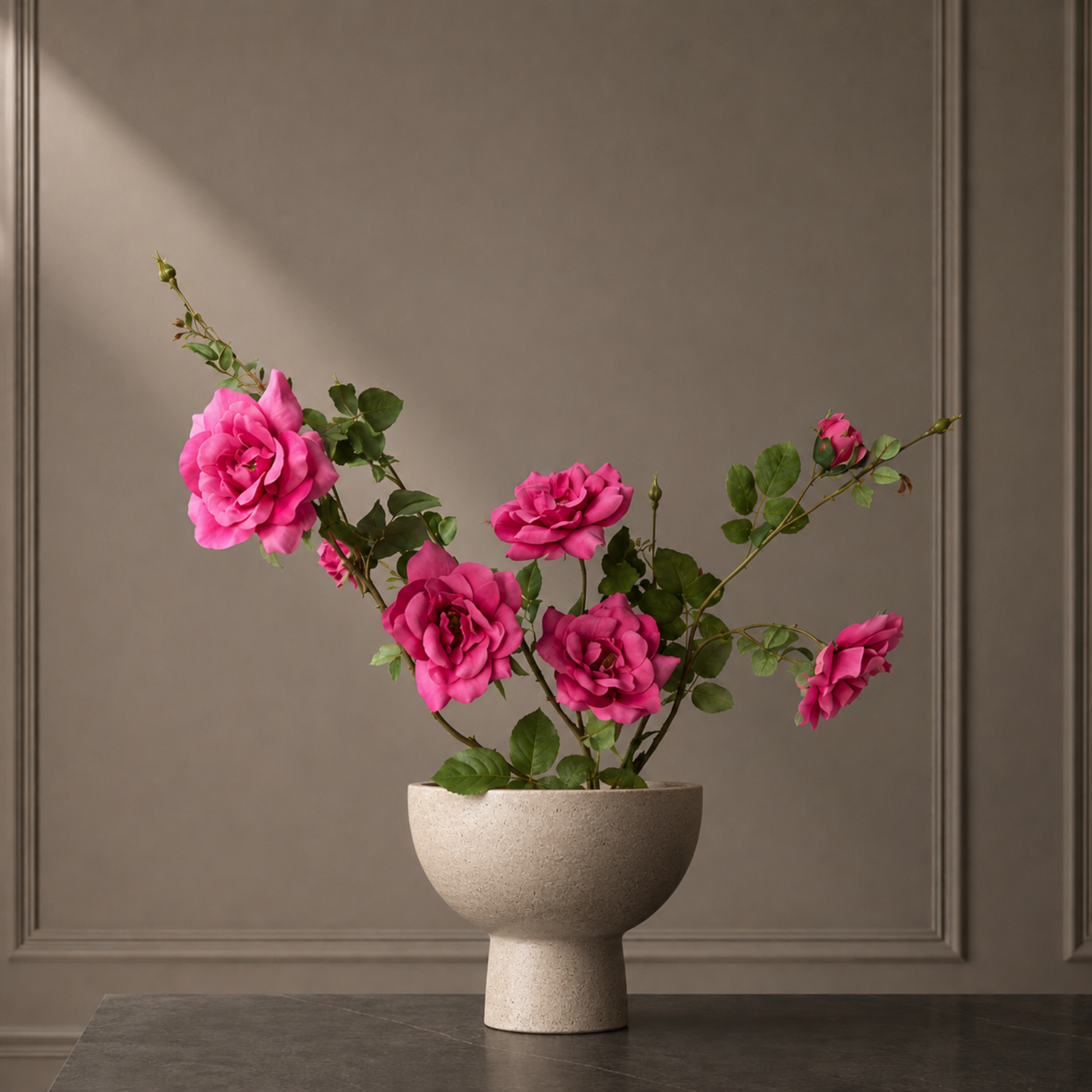 Luxury arrangement of vibrant pink real touch garden rose stems styled in a sculptural stone vase
