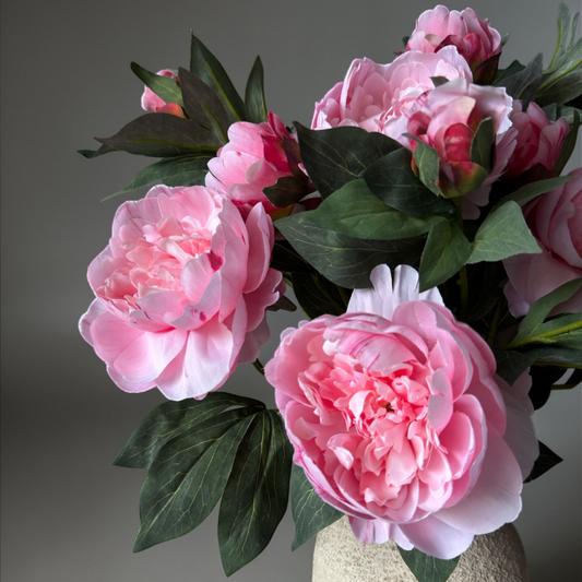 Luxe zijden pioen boeket met zachte roze pioenrozen en realistisch groen blad in een keramische vaas, elegant kunstbloemen boeket voor woondecoratie, interieur styling en tijdloze bloemendecoratie.