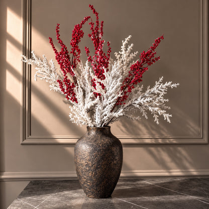 frosted red berry branches with snow-covered white foliage in a textured ceramic vase – artificial Christmas floral arrangement | Jardin Enchanté