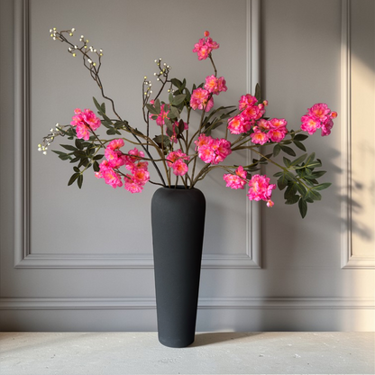 Luxury silk flower bouquet with vibrant pink blossom branches and greenery styled in a modern black vase for home decor and interior styling.