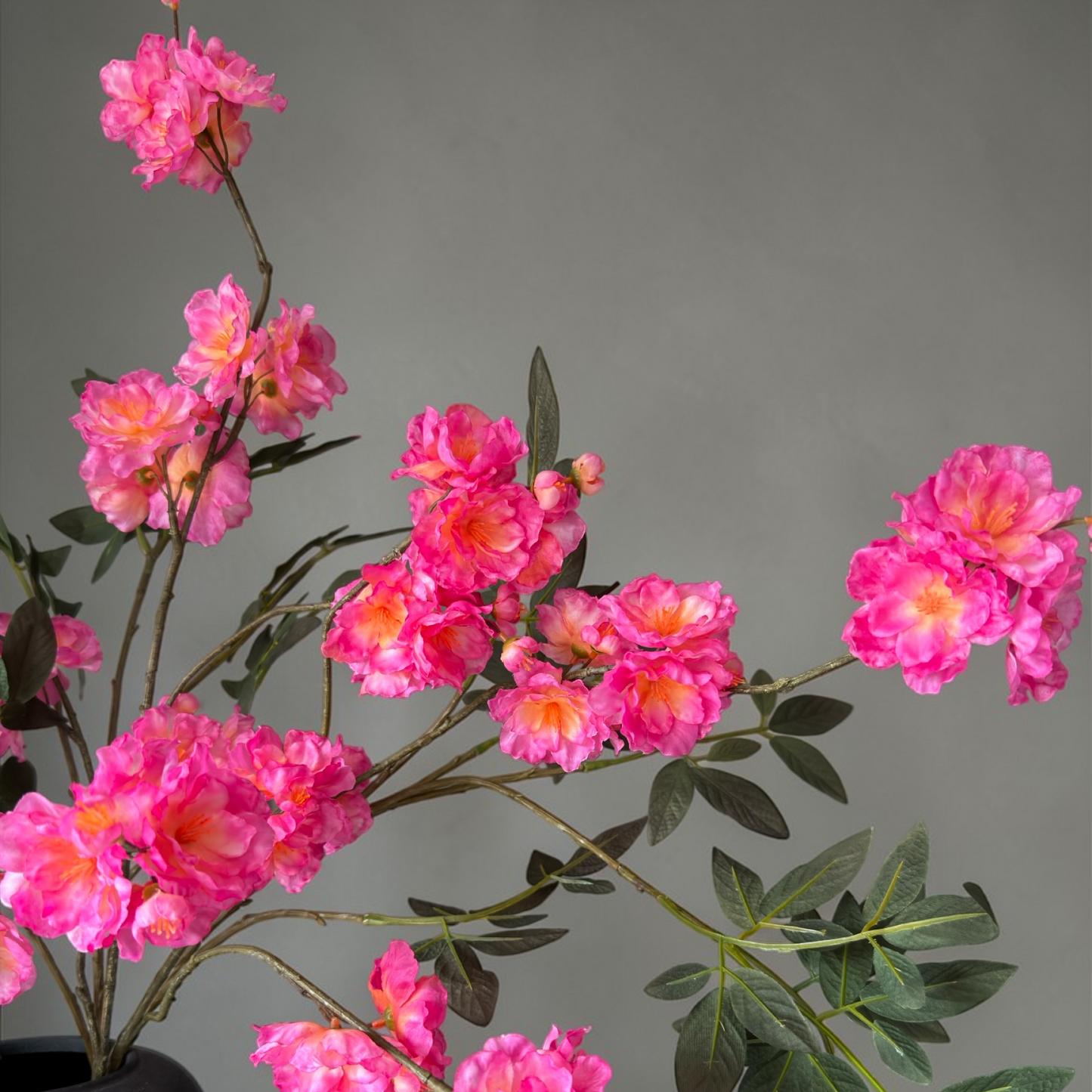 Wild Blossom Bouquet with high-quality silk pink blossoms and natural branches arranged in a tall black vase for elegant home decor and interior styling.