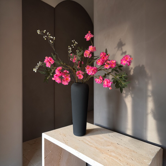 Luxury silk flower bouquet with vibrant pink blossom branches and greenery styled in a modern black vase for home decor and interior styling.