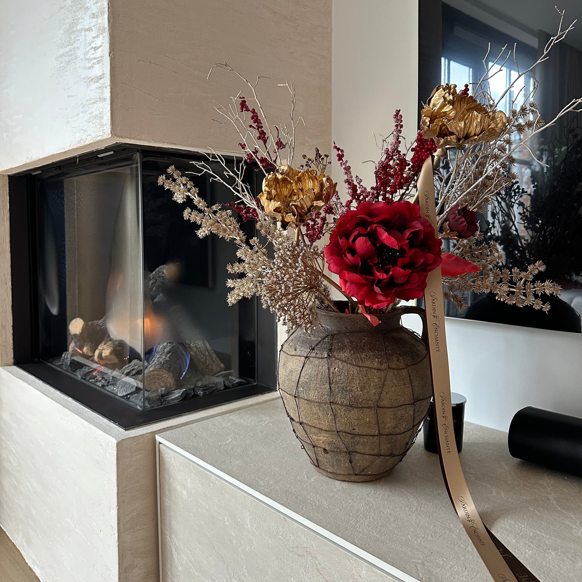 Rijk winterboeket van kunstbloemen met rode pioen, gouden papaver en groene bladeren – stijlvolle decoratie voor woonkamer, eettafel of kerstinterieur.